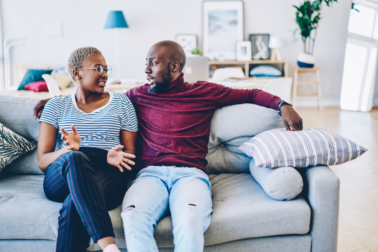 A couple talking on their sofa at home