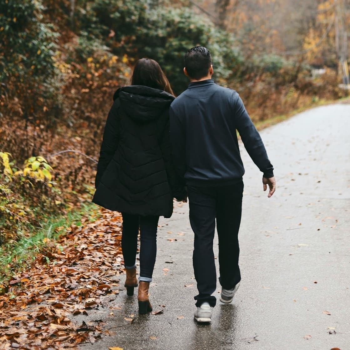 A couple walking together on a wooded path