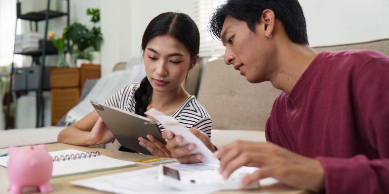 Finances and Collaboration. A couple discussing their financial plan using a tablet and documents for budgeting together